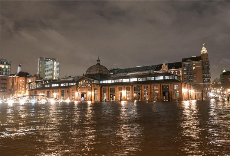Der Fischmarkt mit der Fischauktionshalle steht am frühen Morgen während des Hochwassers der Elbe unter Wasser. 