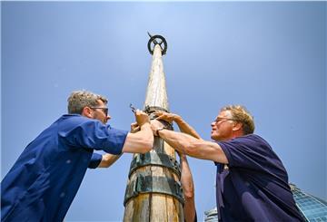 Der Förderverein des Deutschen Schifffahrtsmuseums hat den massiven Metallring zur Erinnerung an die Sturmflut 2013 gestiftet. Am Freitag schraubten der Vereinsvorsitzende Jörg Schulz (rechts) und Lars Krüger vom DSM die Marke an den Sturmflutmast. Foto Scheschonka
