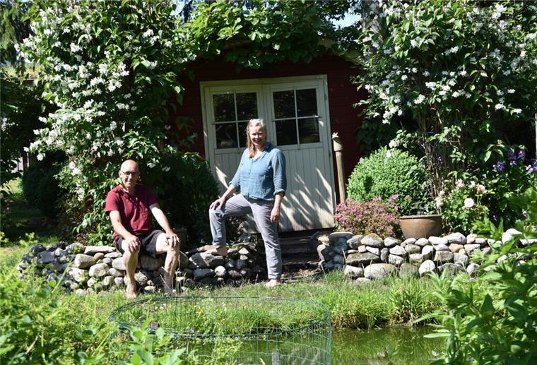 „Offene Gartenpforte“ 2024: Wer seinen privaten Garten öffnen möchte, kann sich jetzt anmelden! Mann und Frau vor einer Hütte in einem Garten.