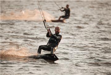 Zwei Kitesurfer auf dem Wasser.