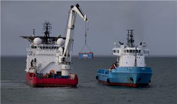 Der Kran des Offshore-Versorgungsschiffs hebt einen Container auf ein anderes Schiff. Von dort wird er zu einem nahe gelegenen Hafen transportiert. Ab Donnerstag soll auch auf deutscher Seite mit der Bergung begonnen werden. 