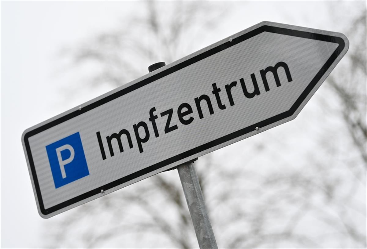 Ein Wegweiser zeigt zum Parkplatz für ein Impfzentrum.