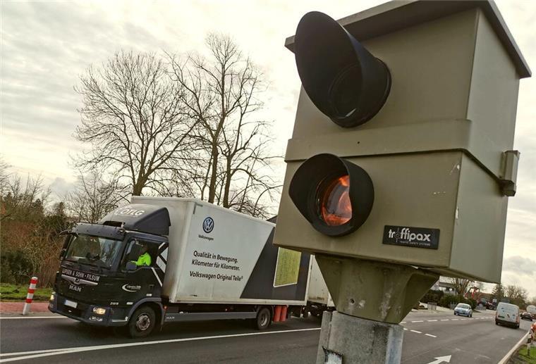Stationärer Blitzer an einer Straße, im Hintergrund fährt ein Lastwagen