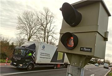Stationärer Blitzer an einer Straße, im Hintergrund fährt ein Lastwagen