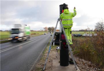 Ein Mann baut einen Blitzer an der L119 bei Neuenwalde auf.
