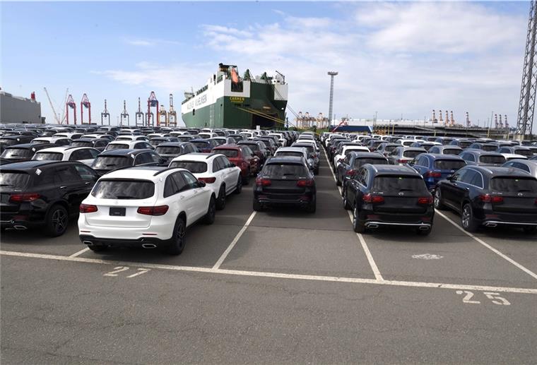 Autos im Hafen vor einem Schiff