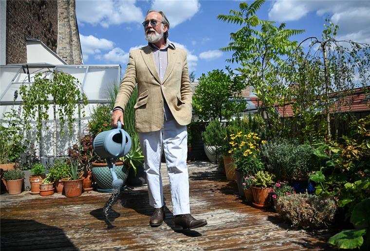 Der Musiker und Schauspieler Friedrich Liechtenstein gießt auf der Terrasse seiner Wohnung die Blumen.