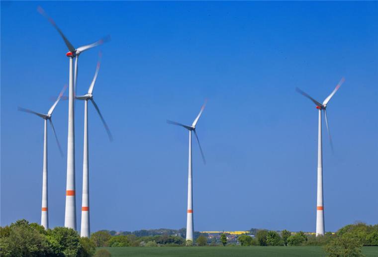 Krass: In Nordenham könnte bald Strom für 48.500 Haushalte produziert werden Mehrere Windräder stehen auf einem Feld bei blauem Himmel