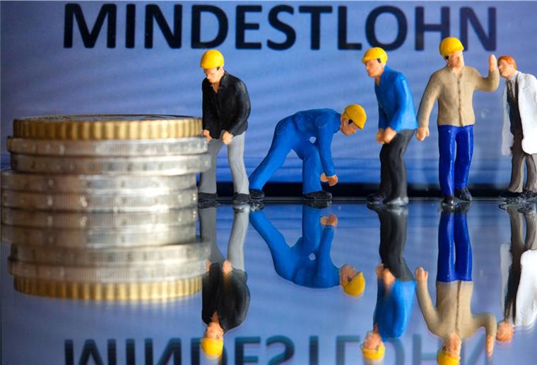 Experte: Mindestlohn von 12 Euro notwendig und richtig Miniaturfiguren stehen am 26.02.2015 in Schwerin (Mecklenburg-Vorpommern) vor einem Display mit der Anzeige «Mindestlohn» (gestelltes Foto).