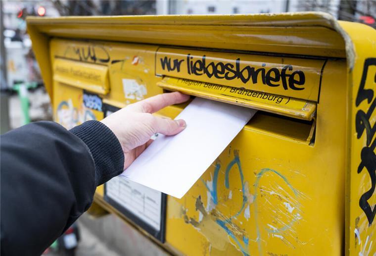 Postgesetz-Reform: Bundespolitiker fordern niedrigeres Briefporto Ein Mann wirft einen Brief in einen Briefkasten