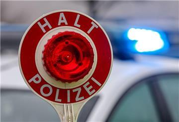 Ein Polizist hält eine Polizeikelle für eine Kontrolle auf einem Parkplatz an der Autobahn 72.