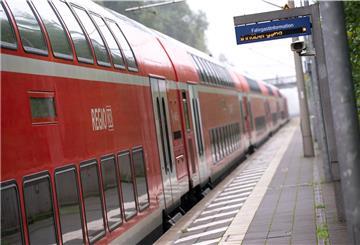 Ein doppelstöckiger Regionalzug der Deutschen Bahn (DB) fährt durch einen Bahnhof. 