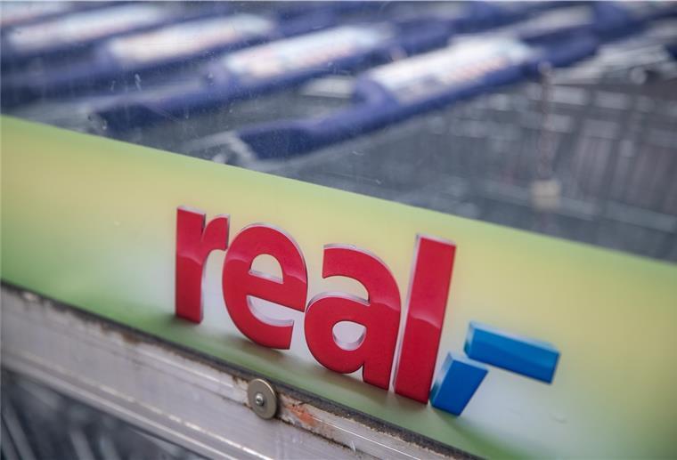 Real-Markt in Spaden: Zukunft gesichert Das "Real"-Logo ist an einem Unterstand für Einkaufswagen des Real Supermarktes zu sehen.