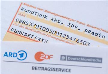 Eine schriftliche Banküberweisung liegt auf dem GEZ-Dokument.