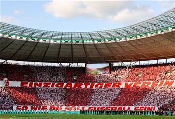 Der Schal-Streit hat keinen Einfluss auf die Stimmung: Freiburger Fans feiern vor dem Spiel auf der Tribüne ihr Team mit einem Transparent mit der Aufschrift "Einzigartiger Verein, so wie Du soll Fußball sein!"
