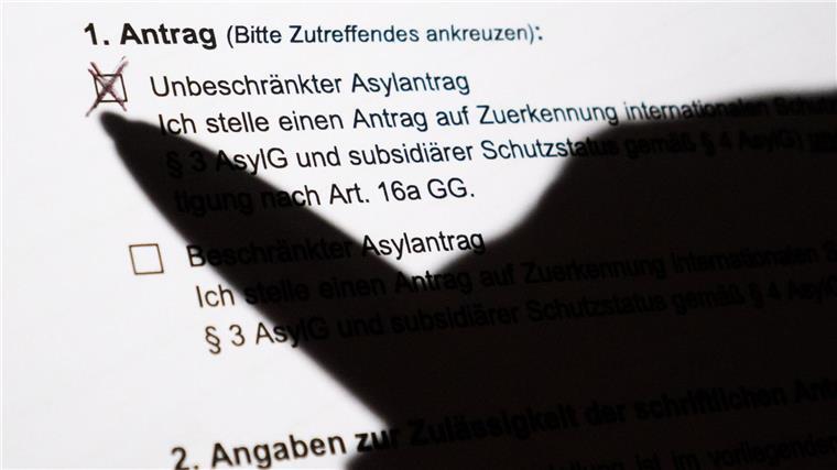 Zahl der Asylsuchenden auf höchstem Stand seit Jahren Der Schatten eines Kugelschreibers zeichnet sich auf einem Asylerstantrag ab.
