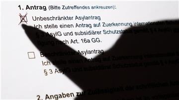 Der Schatten eines Kugelschreibers zeichnet sich auf einem Asylerstantrag ab.