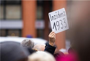 Der Schriftzug «Inzidenz 1933» ist auf einem Schild zu lesen, das ein Mann bei einer Kundgebung in Hannover hochhält.