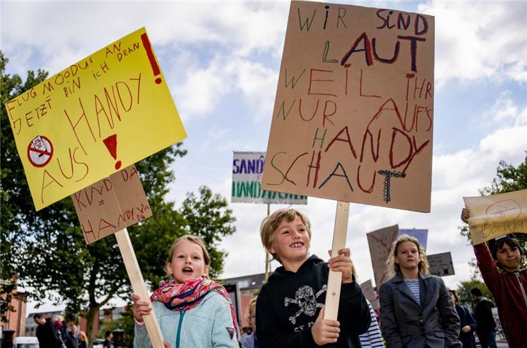 Kinder demonstrieren gegen Handy-Konsum ihrer Eltern Der siebenjährige Emil hat mit Hilfe seiner Mutter eine Kinderdemo unter dem Motto "Spielt mit mir! Nicht mit Euren Handys" organisiert.