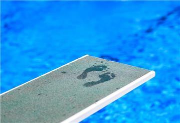 Fußabdrücke eines Badegastes sind auf einem Ein-Meter-Brett in einem Freibad zu sehen