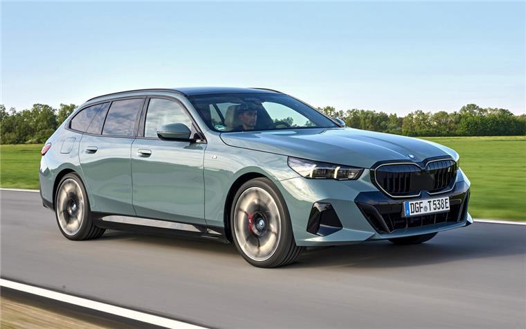 Der BMW i5 in Mintgrün auf einer Landstraße