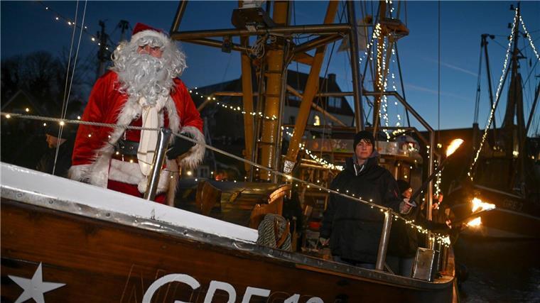Weihnachtsmann kommt mit Fischkutter in Greetsieler Hafen an Der Weihnachstsmann kommt mit einem Fischkutter im Hafen an.