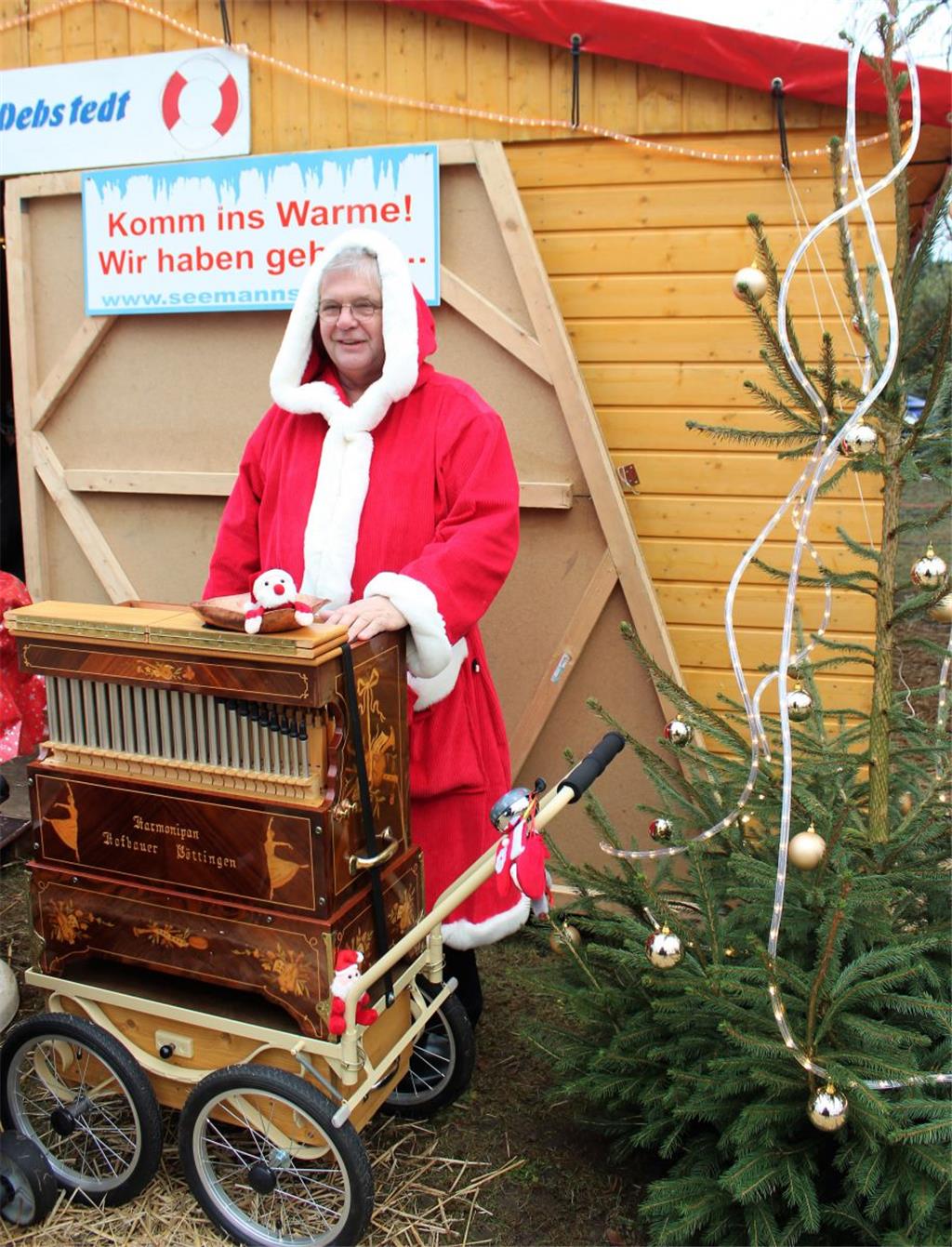 Der Weihnachtsmann steht an der Drehorgel.