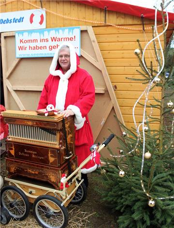 Der Weihnachtsmann steht an der Drehorgel.