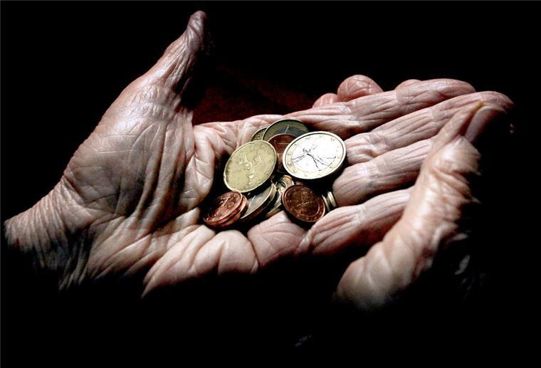 Eine ältere Frau hält Geld in der Hand, genauer: Münzen. Der Zuschuss zur Krankenversicherung kann Rentnern viel Geld sparen.