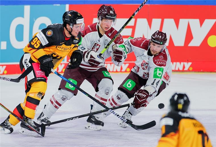 Deutschlands Frederik Tiffels (links) und Lettlands Arvils Bergmanis und Rihards Bukarts (rechts) versuchen an den Puck zu kommen.