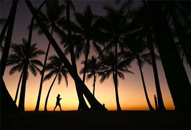 36 Tage auf See: Mini-Schiff startet XXL-Kreuzfahrt zu den Kapverden Eine Person geht am Strand entlang, während die Sonne über Palm Cove, nördlich von Cairns in Queensland, aufgeht.