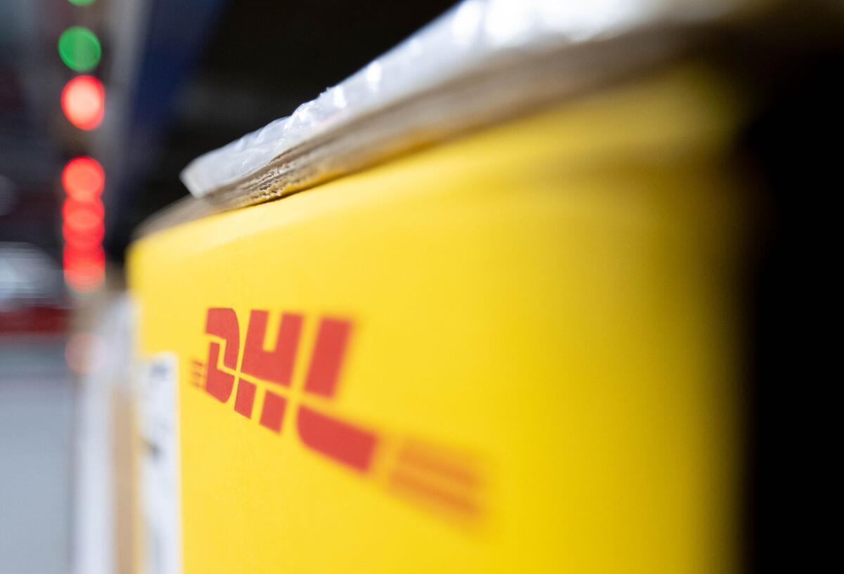 Das Logo von DHL an einer Packstation