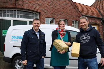Diadema-Leiter Ronny Kollmann-Gruhl, Elisabeth Bruns-Rohde vom Hof Butendiek und Fahrer Kai Krüger freuen sich, dass die Altenheime der Diakonie im Oldenburger Land mit Bio-Käse aus der Region versorgt werden. Foto: Kempermann/Diakonie