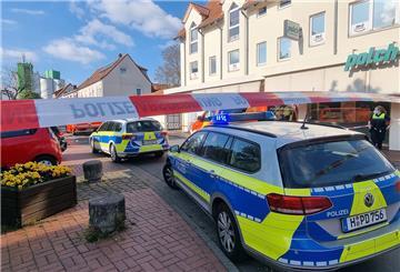 Einsatzfahrzeuge der Polizei stehen am abgesperrten Tatort, wo eine Frau von einem Mann mit einem Messer getötet wurde. 