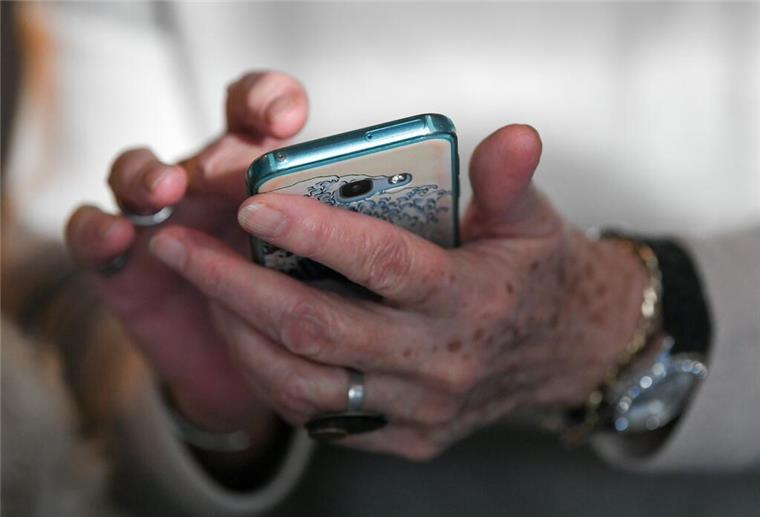90-Jährige entlarvt drei Trickdiebe und verjagt sie Eine Seniorin hält ihr Smartphone in den Händen