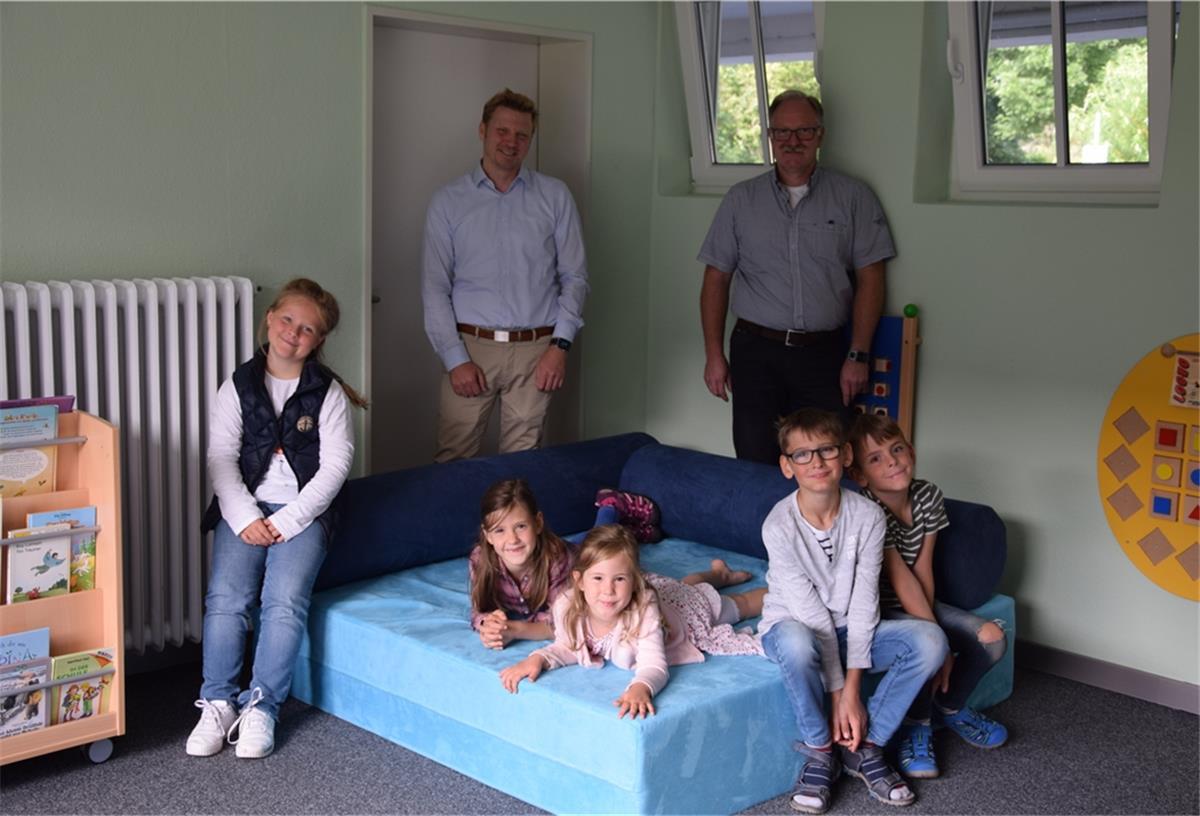 Die Abbehauser Kinder freuen sich über den Ruhe- und Bewegungsraum – ebenso wie Schulleiter Helge Plöger (links) und Ralf Hesse, der die Glückspfennig-Aktion von Premium Aerotec beauftragt.