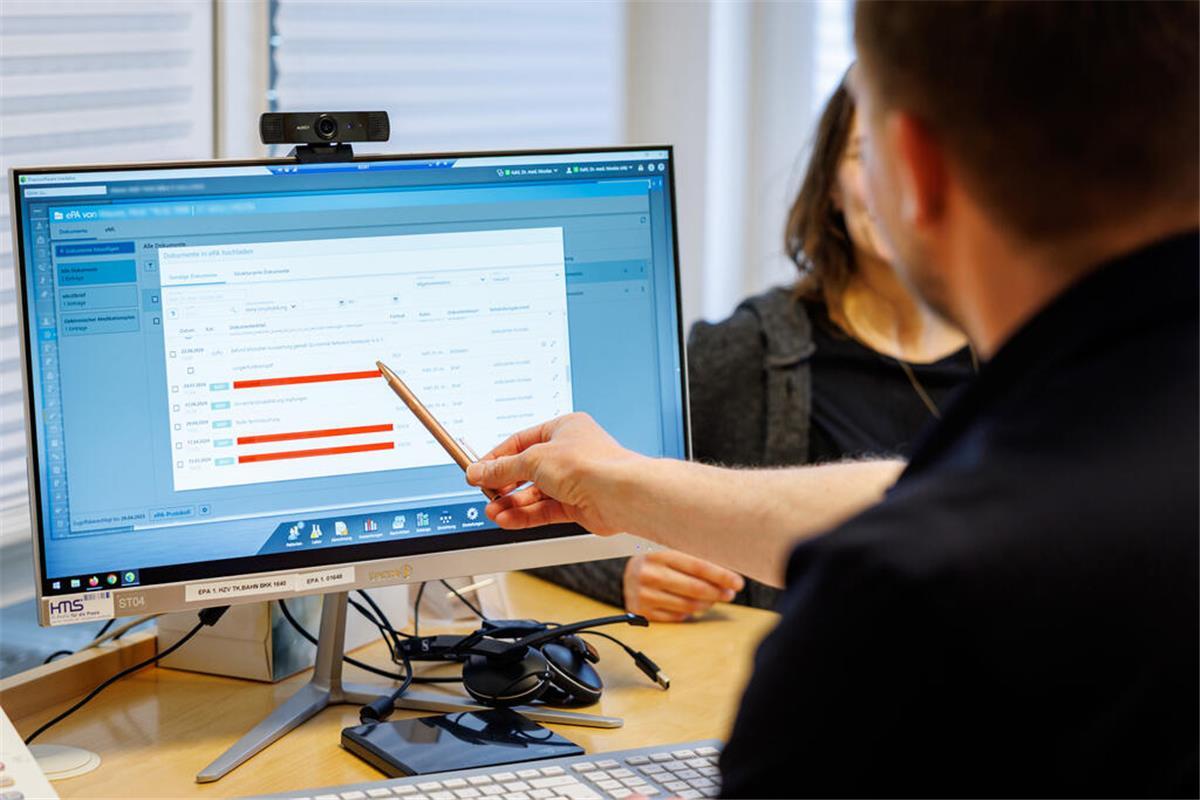 Ein Hausarzt lädt in seiner Praxis Dokumente in eine elektronische Patientenakte "ePA". 