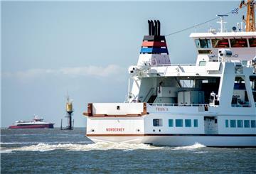 Das Fährschiff „Frisia IV“ ist im Wattenmeer vor der Insel Norderney unterwegs, während sich im Hintergrund der Katamaran MS „Adler Rüm Hart“ der Insel nähert.