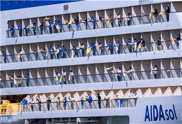 esatzungsmitglieder winken mit Badehandtüchern von den Balkons des Kreuzfahrtschiff "Aidasol" beim Einlaufen in den Hafen. 