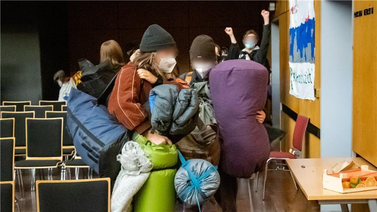 Die Aktivisten verlassen mit ihren Schlafsäcken und Isomatten die Aula.