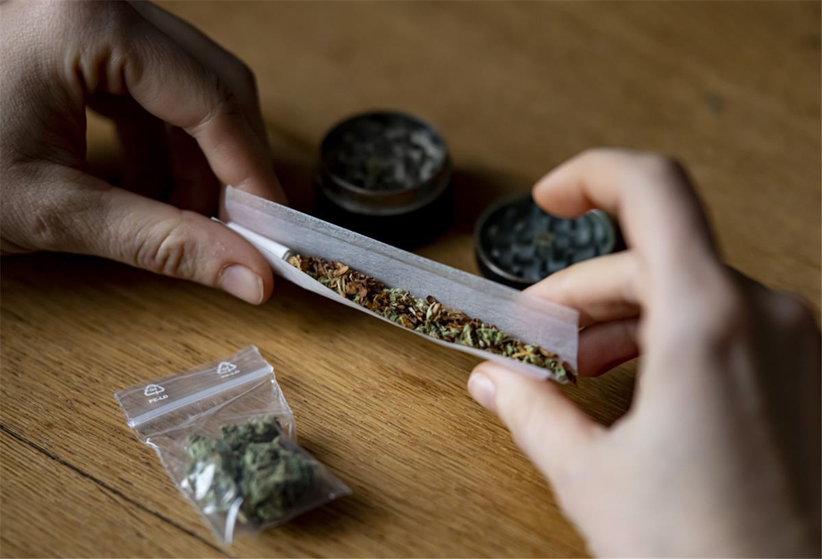 So steht es um die kontrollierte Cannabis-Abgabe in Deutschland Eine Person dreht sich einen Joint.