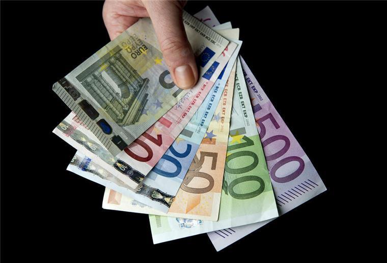 Weltweit mehr Millionäre – nur in Deutschland schrumpft der Club Eine Hand hält zahlreiche Euro-Banknoten.