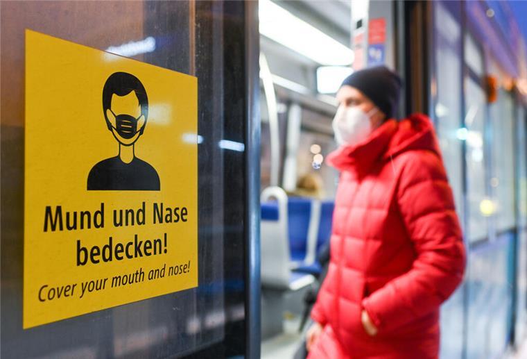 Maskenpflicht im Bahnverkehr ab Februar komplett aufgehoben In einer arrangierten Situation steigt eine Frau, die eine FFP2-Maske trägt, in eine Bahn ein.