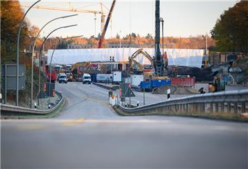 Bagger, Kräne und weitere Baufahrzeuge arbeiten an Brücken über die A7.