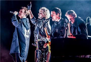 Die Band „Kraftklub“ steht bei der Eröffnung des Reeperbahn-Festivals gemeinsam mit Sänger Bill Kaulitz (2. v l) auf der für den Verkehr gesperrten Reeperbahn auf der Bühne