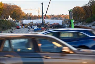 Autos fahren auf einer Brücke über die A7 während im Hintergrund Bauarbeiten stattfinden.
