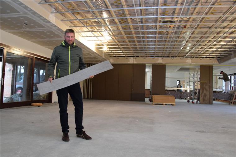 Rockstedt: "Haus im Löh" bald nahezu komplett modernisiert Die Bauarbeiten im „Haus im Löh“ in Rockstedt schreiten voran. Der stellvertretende Gemeindebürgermeister Volker Borchers zeigt den Design-Belag in Holz-Optik, der bald den Fußboden zieren soll. Zudem wird der Saal mit einer Akustikdecke ausgestattet.