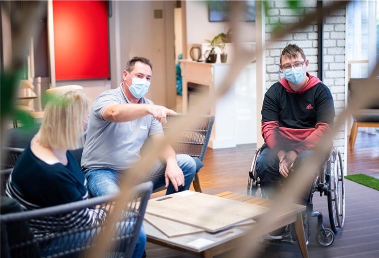 Unser Traumhaus in Dorum: So wohnt man heute an der Küste Die Bauherren Yvonne und Marvin Holst schauen mit Raumausstatter Christian Schnakenberg verschiedene Design-Bodenbeläge in Holzoptik an.