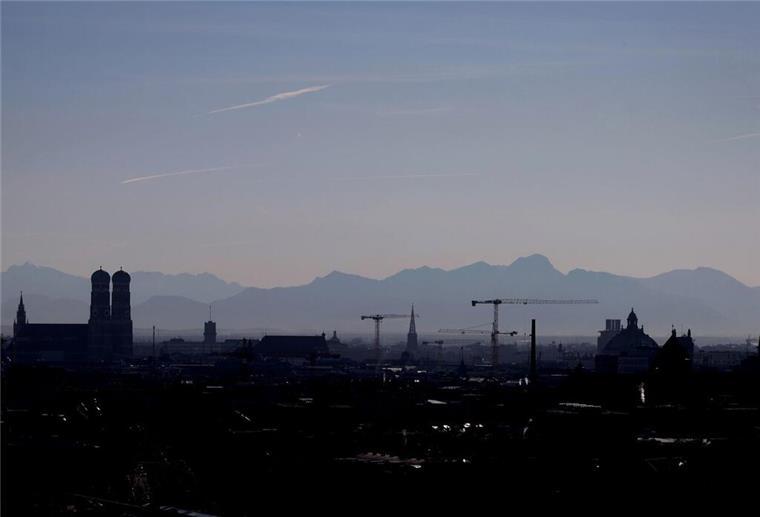 Neues Ranking zeigt große Unterschiede: Das ist Deutschlands smarteste Stadt Die Umrisse der Frauenkirche (l) und von Baukränen zeichnen sich vor dem Panorama der Alpen ab