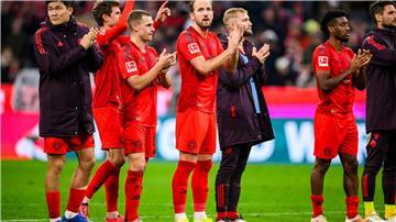 Die Bayern, in der Mitte der zweifache Torschütze Harry Kane, feiern das 3:0 gegen Union Berlin vor der Fankurve. 